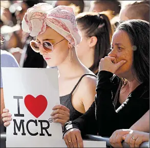  ?? AP/KIRSTY WIGGLESWOR­TH ?? Mourners attend a vigil Tuesday in Manchester, England, for the victims of Monday’s attack.