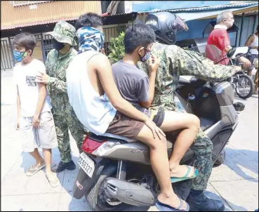  ?? EDD GUMBAN ?? Police apprehend minors loitering along the streets of Tondo in Manila yesterday.