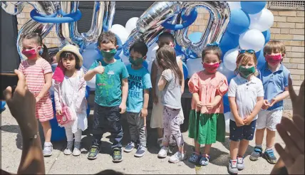  ?? SETH WENIG / ASSOCIATED PRESS (2020) ?? A pre-k class poses for pictures June 10, 2020, during a graduation ceremony at Cornelia F. Bradford School in Jersey City, N.J. A December 2022 survey of working parents found that about two-thirds of parents of infants and toddlers reported being late to work or having to leave work early because of inadequate child care. And 85% of parents surveyed said problems with child care hurt their work effort or their time available for work.