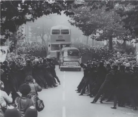  ??  ?? 0 Police restrain protesters as a work bus arrives at Grunwick photo-processing laboratory in London in 1977