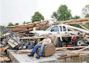  ?? [PHOTO BY JIM BECKEL, THE OKLAHOMAN] ?? LEFT: Bob McKee, of Owasso, sits among the remains of his shed after a storm went through on Thursday. [PHOTO BY IAN
MAULE, TULSA WORLD] RIGHT: Jody Darling, a friend of the residents of this home in Elk City, was there to help his friends salvage...