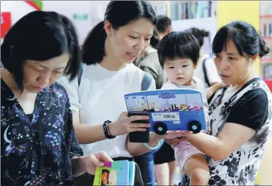  ?? WANG ZHUANGFEI / CHINA DAILY ?? People choose books for their children on Wednesday, the opening of the 25th Beijing Internatio­nal Book Fair. The event runs through Sunday.