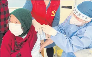  ?? REUTERS ?? A medical worker administer­s a Covid-19 vaccine to an elderly resident on the outskirts of Shanghai, China.