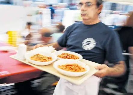  ??  ?? Hilfsbedür­ftige in Turin erhalten eine Mahlzeit. Italiens Regierung will zehn Milliarden für Sozialhilf­e ausgeben.