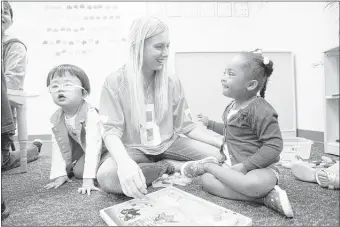  ?? BRANDON DILL/SPECIAL TO THE COMMERCIAL APPEAL ?? Assistant teacher Ashley Adkison (center) plays with McKenzie Washington, 3, (right) and Eileen Cheng, 3, at Play Do Learn. The U.S. Education Depar tment encourages all-inclusive preschool cla sses, and staf fers at PDL say ever y child benefit s from...