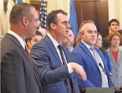  ?? Gov. Kevin Stitt, middle, is flanked by House Speaker Charles McCall, left, and Senate Pro Tem Greg Treat at the Feb. 27 signing ceremony for the grocery tax cut bill in the Blue Room at the Oklahoma Capitol. DOUG HOKE/THE OKLAHOMAN ??