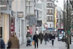  ?? AFP ?? People walk past a branch of Next retail store on Oxford Street in central London on Wednesday. British clothing retailer Next on Wednesday warned of a tougher trading year ahead as a weak pound caused by Brexit uncertaint­y pushes up raw material...