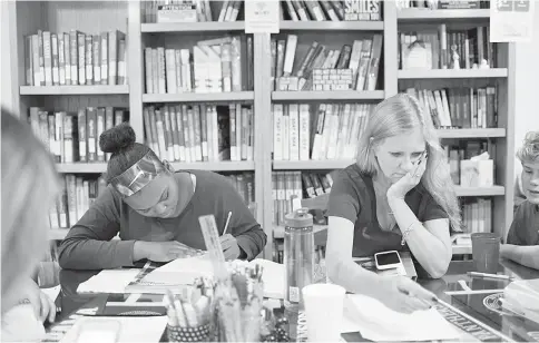  ??  ?? Lauren Dent, left, an eighth-grader at Washington Irving Middle School, studies while Ross checks a client’s work and (below) Ross tutors a client at Profession­al Tutoring, her family business in Fairfax Station,Virginia. — WP-Bloomberg photos courtesy...