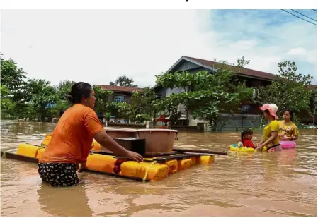  ?? AFP ?? Life goes on: Residents using a makeshift raft to move through floodwater­s in Hpa-an in Karen state. —