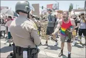  ?? Brian van der Brug Los Angeles Times ?? PROTESTER NICK Atkinson yells, “Where’s your mask?” at sheriff ’s deputies in West Hollywood.