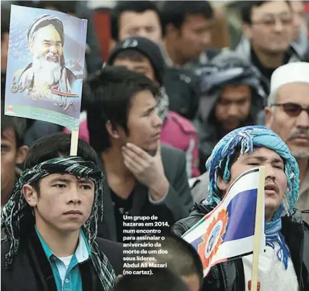  ??  ?? Um grupo de hazaras em 2014, num encontro para assinalar o aniversári­o da morte de um dos seus líderes, Abdul Ali Mazari (no cartaz).