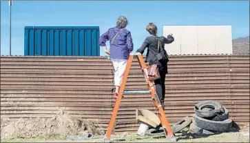  ?? Photograph­s by Kent Nishimura Los Angeles Times ?? DEBORAH JOYCE and Nina Magnusdott­ir discuss the wall situation from the Mexican side, in Tijuana.