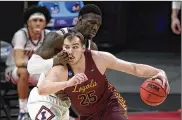  ?? PAUL SANCYA / AP ?? Cameron Krutwig, driving pass Illinois’ Kofi Cockburn, has been both the engine and conductor for Loyola Chicago. He’s the first center in 15 years to win Missouri Valley Conference player of the year honors .