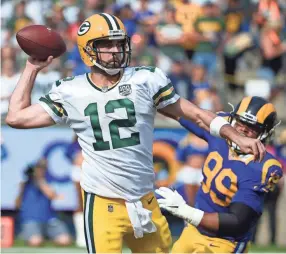  ??  ?? Packers quarterbac­k Aaron Rodgers throws a pass under pressure from Rams defensive tackle Aaron Donald on Sunday in Los Angeles. DENIS POROY/AP