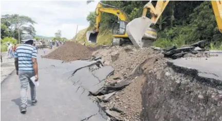  ??  ?? Roadwork under way yesterday afternoon to restore access to the Junction main road in St Mary, where a section of the road collapsed.