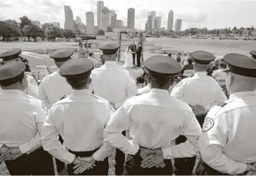  ?? Melissa Phillip / Houston Chronicle ?? Houston Police Cadets watch the wedding of Cynthia Martin and Daniel Florek officiated by HPD chaplain Monty Montgomery at the Houston Police Officer Memorial on Saturday.