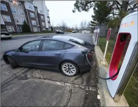  ?? (AP) ?? A Tesla sedan charges at a Tesla Supercharg­ing station in November at Cranberry, Pa.