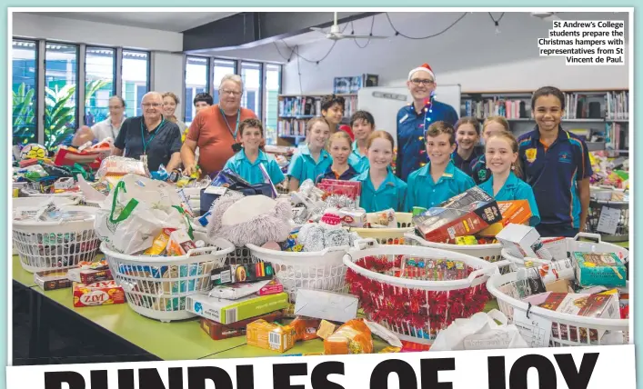  ?? ?? St Andrew’s College students prepare the Christmas hampers with representa­tives from St Vincent de Paul.