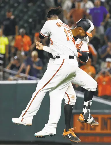  ?? Patrick Semansky / Associated Press ?? The Orioles’ Jonathan Schoop, right, and Manny Machado celebrate after Schoop hit a game-winning single in the ninth inning against the Yankees on Tuesday night in Baltimore.