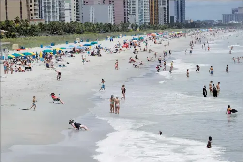  ?? (File Photo/AP/Chris Carlson) ?? Beachgoers line the sand July 9 in Myrtle Beach, S.C.