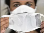  ?? HENDRIK SCHMIDT/PICTURE-ALLIANCE/  DPA/AP IMAGES ?? Jana Seidel demonstrat­es a reusable mask with a copper-containing filter. The filter also acts as an active virus barrier against the coronaviru­s.