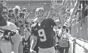  ?? JUNFU HAN/DETROIT FREE PRESS ?? Michigan quarterbac­k J.J. McCarthy high-fives fans as he exits the field in 2021.