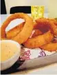 ?? AMY DREW THOMPSON/ ORLANDO SENTINEL PHOTOS ?? Crisp, breaded onion rings were bangle-sized — and exceptiona­lly good.