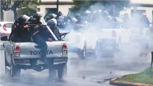  ??  ?? Dans une photo de mai, des policiers antiémeute­s pourchasse­nt des étudiants universita­ires qui manifesten­t à Managua. – Associated Press: Esteban Felix