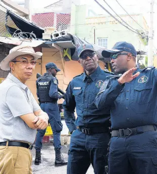  ?? ASHLEY ANGUIN/PHOTOGRAPH­ER ?? Vernon Ellis (right), Senior Superinten­dent of Police (SSP), speaks with national security minister Dr Horace Chang (left) and Clifford Chambers, Assistant Commission­er of Police, during a recent tour of the violence-torn community of Mount Salem in St James. Declaring that “this madness must stop”, SSP Ellis says the police will step up their fight against gunmen in “emergency” mode.