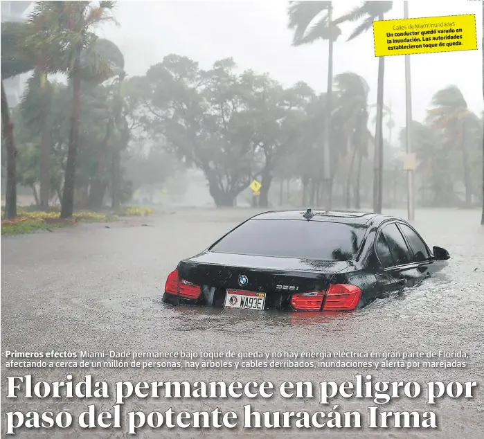  ?? FOTO: AFP ?? varado en Un conductor quedó autoridade­s la inundación. Las de queda. establecie­ron toque de Miami inundadas Calles