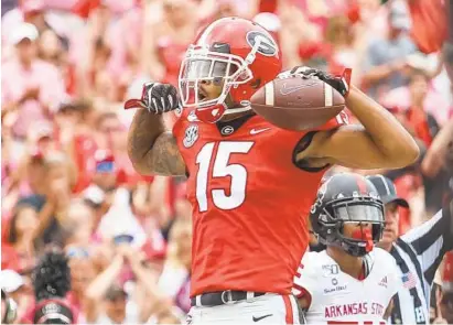  ?? CARMEN MANDATO/GETTY ?? Georgia receiver Lawrence Cager celebrates a touchdown reception against Arkansas State at Sanford Stadium on Sept. 14, 2019.