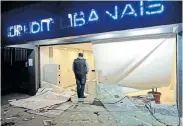  ?? Picture: ANWAR AMRO/AFP ?? CHAOS ERUPTS: A man stands at the entrance of a bank that was vandalised by anti-government protesters yesterday, in Lebanon’s capital, Beirut