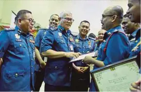  ?? PIC BY ADZLAN SIDEK ?? Fire and Rescue Department director-general Datuk Mohammad Hamdan Wahid (centre) greeting award recipients at the Negri Sembilan Fire and Rescue Department Excellence Service awards ceremony in Seremban yesterday.