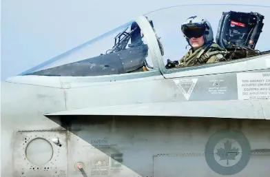  ?? ALBERTO PIZZOLI / AFP / GETTY IMAGES FILES ?? A Canadian CF-18 jet pilot from 3 Wing Bagotville, Que., sits in his plane upon arrival from a mission. The auditor general’s report warned Tuesday that Canada’s fighter jet capabiliti­es are being limited by a lack of trained pilots.