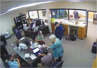  ?? COFFEE COUNTY, GA., VIA AP, FILE ?? In 2021, Cathy Latham, center, is seen in the Douglas, Ga., elections office while a computer forensics team was there to make copies of voting equipment. Latham was the county Republican Party chair at the time.