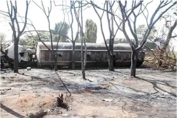  ?? — AFP ?? Burnt trees and the carcass of a burnt out fuel tanker is seen along the side of the road following an explosion on Saturday in Morogoro, 200 kilometres west of the Tanzanian capital Dar-es-salaam.