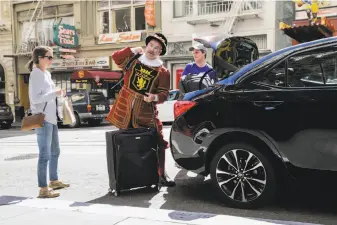  ?? Gabrielle Lurie / The Chronicle ?? Kimpton Sir Francis Drake Hotel doorman Tom Sweeney, on the job since 1976, grabs bags of luggage as guests check in earlier this year.