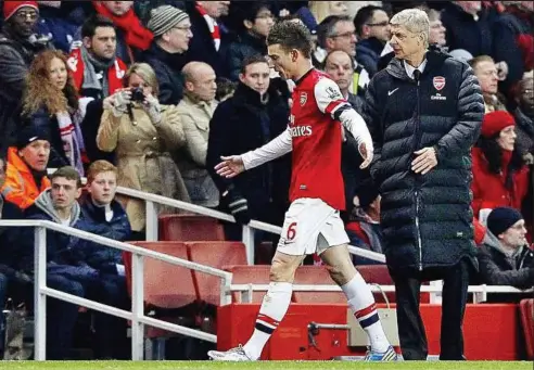  ?? — EPA ?? Huge embarrassm­ent: Laurent Koscielny of Arsenal passes manager Arsene Wenger after receiving a red card during the English Premier League match against Manchester City at the Emirates on Sunday.