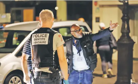  ?? — AFP photo ?? French police is on the scene where a man attacked and injured people in the streets of Paris in the 19th arrondisse­ment.