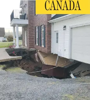  ?? PAUL MAYNARD / THE CANADIAN PRESS ?? A sinkhole appeared under this Falmouth, N.S., house on Sunday. Officials say the family is safe, but the building is expected to collapse soon.