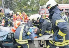  ?? FOTO: L. BERNS ?? Einsatzkrä­fte der Löschzüge Neuss-Furth und Grimlingha­usen schneiden einen Statisten aus dem Unfall-Auto und übergeben ihn an die Sanitäter.