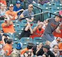  ?? Patrick Smith Getty Images ?? PEOPLE TRY to avoid getting hit by a flying bat at a Baltimore Orioles game inMay at Camden Yards.