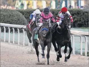  ?? Photos by Tommy Metthe / The Arkansas Democrat-gazette via AP ?? Omaha Beach, right, ridden by Mike Smith, edges out the favorite Game Winner, ridden by Joel Rosario, to win the second division of the Rebel Stakes on Saturday.