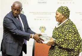  ?? /Reuters ?? Findings: Former chief justice Sandile Ngcobo on Wednesday in Cape Town hands over the report to the speaker of parliament, Nosiviwe Mapisa-Nqakula, on whether President Cyril Ramaphosa should face an impeachmen­t inquiry over the Phala Phala saga.