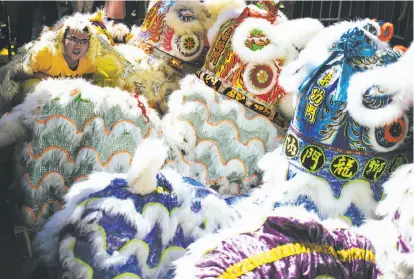  ?? Mason Trinca / Special to The Chronicle ?? Aaron Ng sticks his head out from the costume as hundreds of people await the opening ceremony of the annual Autumn Moon Festival in San Francisco.