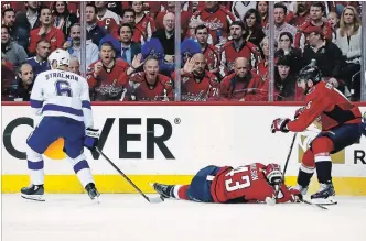  ?? ALEX BRANDON THE ASSOCIATED PRESS ?? Capitals winger Tom Wilson lies on the ice after a hit by Tampa Bay Lightning defenceman Anton Stralman (6) in Game 3 of their NHL Eastern Conference final playoff series Tuesday night in Washington.