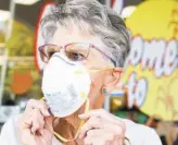  ?? Jessica Christian / The Chronicle ?? Dinah Mattos of Novato wears a respirator mask while purchasing more of them at Pini Ace Hardware in Novato. Air regulators have issued a third straight Spare the Air Alert for Saturday, advising people to stay indoors.