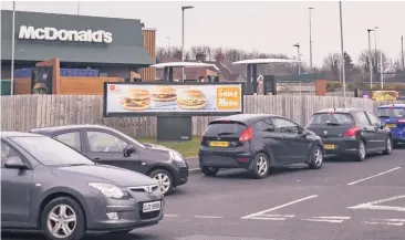  ??  ?? Cars queue at a Mcdonald’s restaurant in Belfast before the lockdown