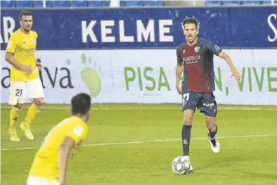  ?? SD HUESCA ?? Juan Carlos conduce el balón bajo la lluvia en el pasado encuentro contra el Cádiz en un Alcoraz vacío.