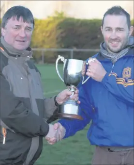  ??  ?? Chief Superinten­dent Thomas Conway presents the cup on behalf of Coiste Siamsa to Wicklow captain Wayne Farrell.